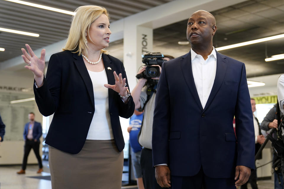 Sen. Tim Scott, R-S.C., tours the Marion Public Library with Rep. Ashley Hinson, R-Iowa, left, Wednesday, April 12, 2023, in Marion, Iowa. Scott on Wednesday launched an exploratory committee for a 2024 GOP presidential bid, a step that comes just shy of making his campaign official. (AP Photo/Charlie Neibergall)