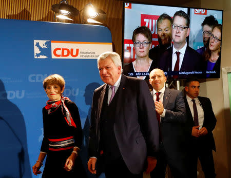 Christian Democratic Union (CDU) top candidate and Hesse State Prime Minister Volker Bouffier walks past a TV screen showing Social Democratic Party (SPD) top candidate Thorsten Schaefer-Guembel after first exit polls following the Hesse state election in Wiesbaden, Germany, October 28, 2018. REUTERS/Kai Pfaffenbach