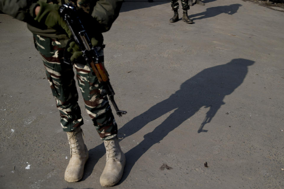 A shadow of an Indian paramilitary soldier is cast as he stands guard at a temporary checkpoint during a strike in Srinagar, Indian controlled Kashmir, Sunday, Feb. 3, 2019. India's prime minster is in disputed Kashmir for a daylong visit Sunday to review development work as separatists fighting Indian rule called for a shutdown in the Himalayan region. (AP Photo/Dar Yasin)