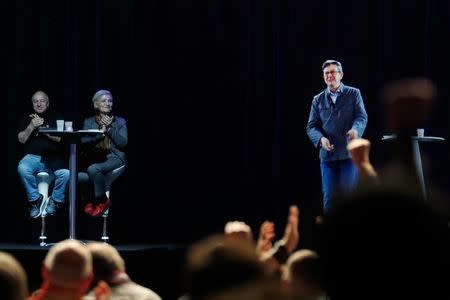 People applaud the hologram of politician Jean-Luc Melenchon (R), of the French far-left Parti de Gauche, and candidate for the 2017 French presidential election, that speaks to supporters who are gathered in Saint-Denis, near Paris, France, February 5, 2017 as Melenchon holds a campaign rally in Lyon. REUTERS/Christian Hartmann