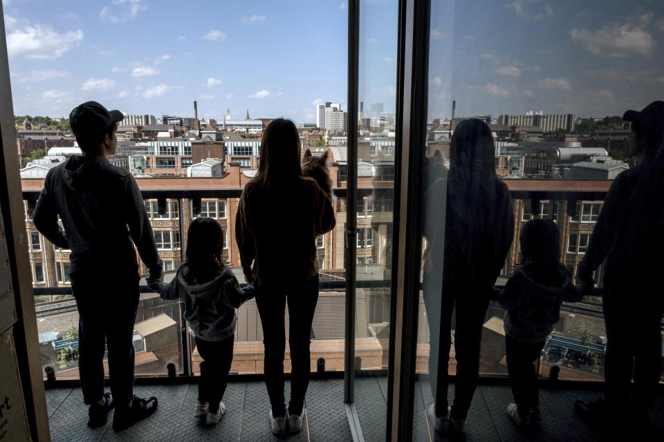 Mike Hui, left, a former photojournalist of Apple Daily newspaper, and his family pose at a balcony in his temporary flat in Leeds, England on June 22, 2021. Until early April, Hui was a photojournalist for the Apple Daily, a pro-democracy newspaper that shut down following the arrest of five top editors and executives and the freezing of its assets under a national security law that China's ruling Communist Party imposed on Hong Kong as part of the crackdown. (AP Photo)