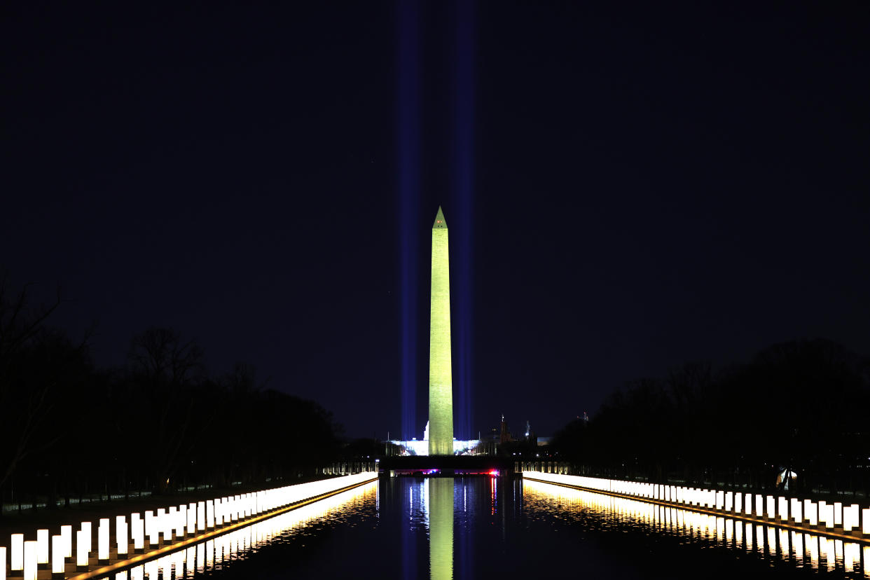 Columns representing 400,000 victims of COVID-19 are lit along the sides of the Lincoln Memorial Reflecting Pool.