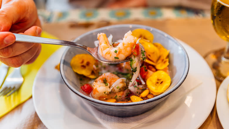 person eating ceviche with spoon