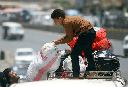 A displaced man from Hodeidah city carries a bag as they reach Sanaa, Yemen. REUTERS/Mohamed al-Sayaghi