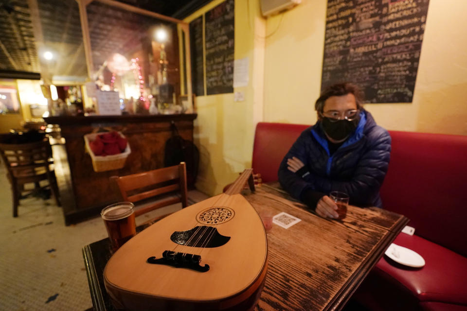 Customer Koray Calistan, has a drink at Barbès, a popular neighborhood music venue and bar converted to a bottle shop to survive the winter during the coronavirus pandemic, Tuesday, Dec. 1, 2020, in New York. (AP Photo/Kathy Willens)