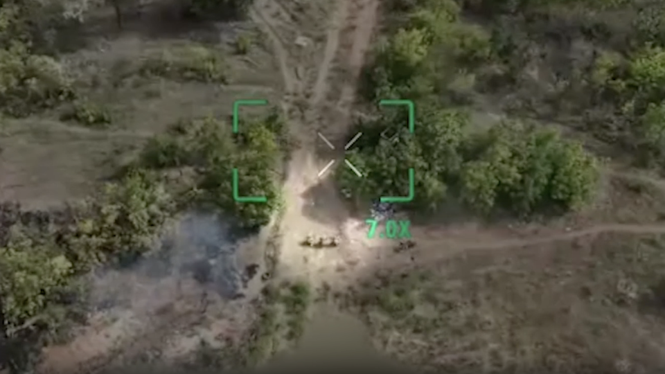 Drone footage from eastern Ukraine last month captures the moment three Ukrainian soldiers stagger onto a dusty track and kneel down, hands on their heads, seeking to surrender. - Obtained by CNN