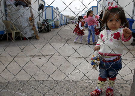 A displaced Christian child, who fled Islamic State, poses for a photograph at Zayuna camp in Baghdad December 23, 2015. REUTERS/Khalid al Mousily