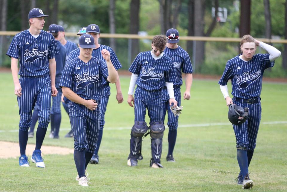 Members of the St. Thomas Aquinas baseball team walk off the field following Wednesday's 9-3 loss to Hollis-Brookline in a Division II semifinal in Concord.