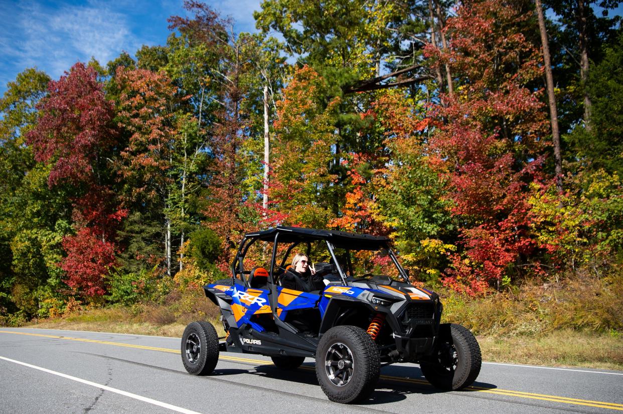 A UTV drives past fall foliage seen along the Foothills Parkway's Missing Link section on Tuesday, Oct. 11, 2022.