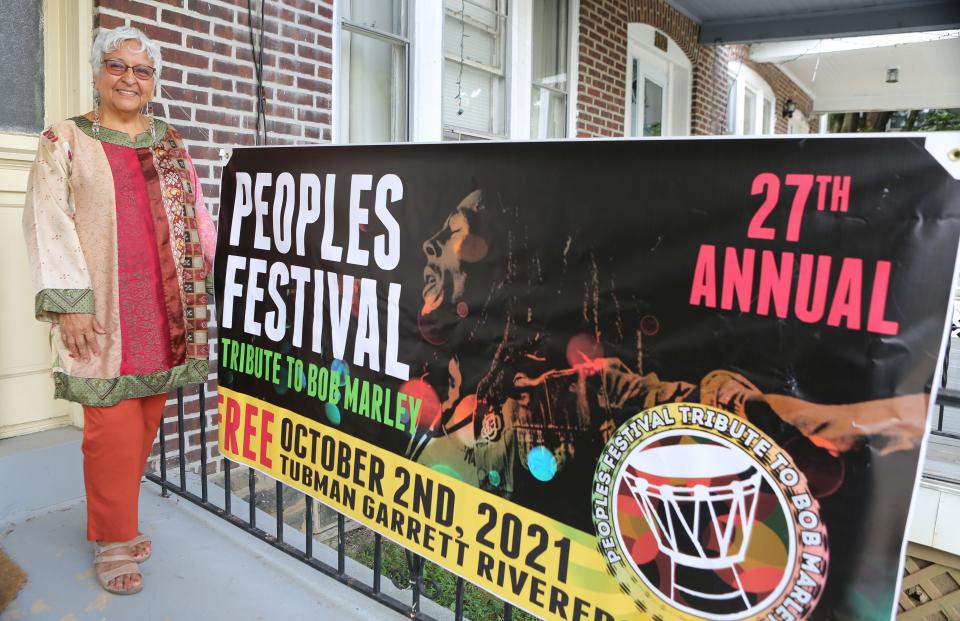 The 28th Peoples festival will return to Tubman Garret Riverfront Park on Sept. 17. Genoveva Pitts, the founder of the Peoples Festival, stands in front of a banner in 2021 that promotes the 27th Peoples Festival, which celebrates the career and legacy of her old friend, Bob Marley.