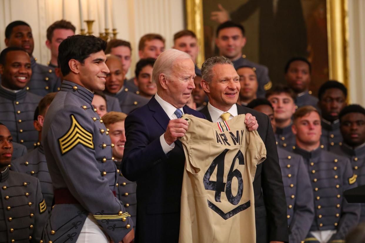 Joe Biden, the 46th president of the United States, receives a commemorative football jersey in a ceremony to honor Army as the Commander-in-Chief Trophy champs on May 6, 2024, in Washington, D.C. Head coach Jeff Monken assists. DANNY WILD/USA TODAY Sports