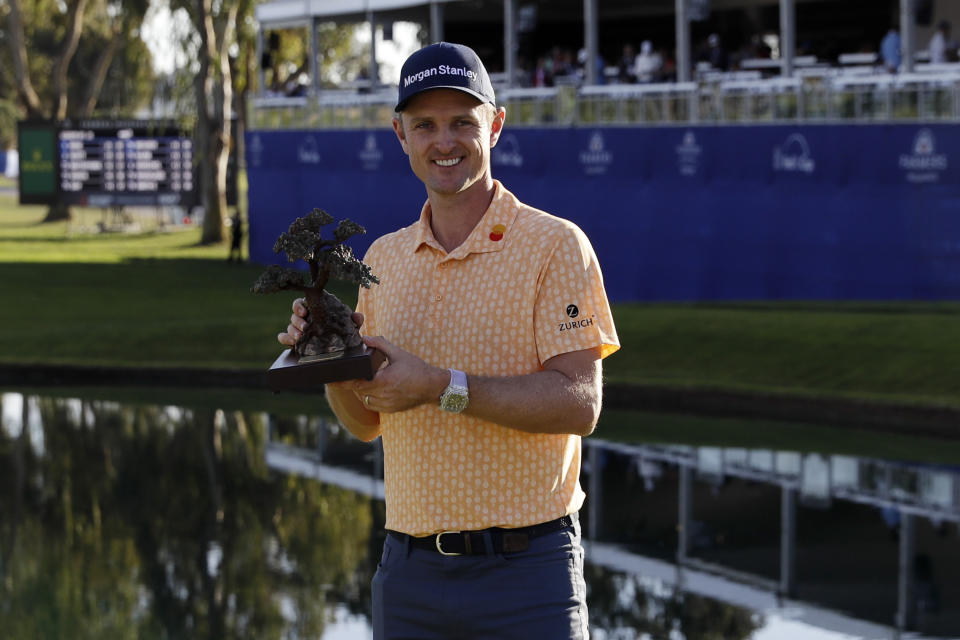 Justin Rose, of England, holds the trophy after winning the Farmers Insurance golf tournament Sunday, Jan. 27, 2019, in San Diego. (AP Photo/Gregory Bull)