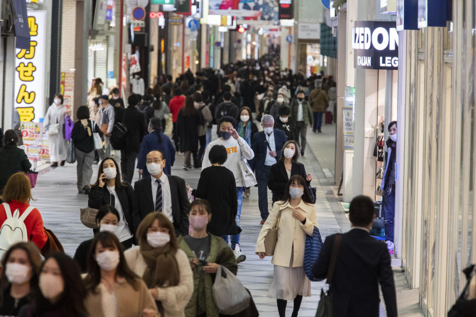 People wearing face masks to help curb the spread of the coronavirus walk through a shopping street in Osaka, western Japan, Thursday, Nov. 26, 2020. (AP Photo/Hiro Komae)