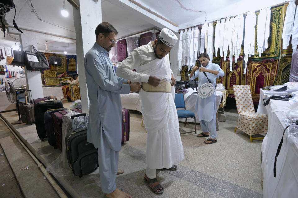 A pilgrim buys a money belt at a Hajj training center in Karachi, Pakistan, Monday, June 19, 2023. Saudi Arabia is hosting its biggest Hajj pilgrimage in three years, starting Monday. But for many pilgrims and others who couldn't make it, global inflation and economic crises made it more of a strain to carry out Islam's spiritual trip of a lifetime. (AP Photo/Fareed Khan)