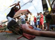 A man whips a devotee during a Maundy Thursday ritual by penitents to atone for sins in Angeles, Pampanga north of Manila April 17, 2014. Flagellation is a form of religious discipline observed every lenten season by Catholic devotees in the Philippines REUTERS/Erik De Castro (PHILIPPINES - Tags: SOCIETY RELIGION TPX IMAGES OF THE DAY)