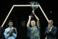 Denmark's Holger Rune celebrates with this trophy after defeating Serbia's Novak Djokovic, left, in their Paris Masters final at the Accor Arena, Sunday, Nov. 6, 2022 in Paris. Rune won 3-6, 6-3, 7-5. (AP Photo/Thibault Camus)