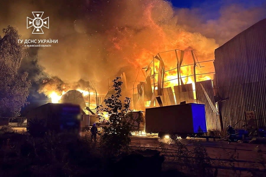 Firefighters work at a site of an industrial warehouse damaged by a Russian drone strike (via REUTERS)