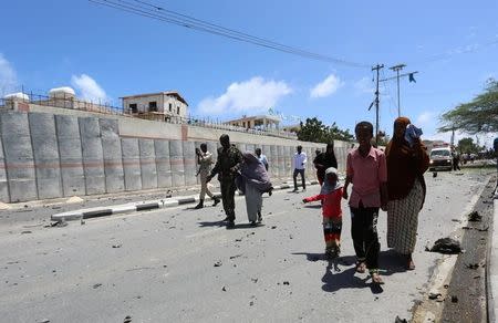 Somali security forces escort civilians following a car bomb claimed by al Shabaab Islamist militants outside the president's palace in the Somali capital of Mogadishu, August 30, 2016. REUTERS/Feisal Omar