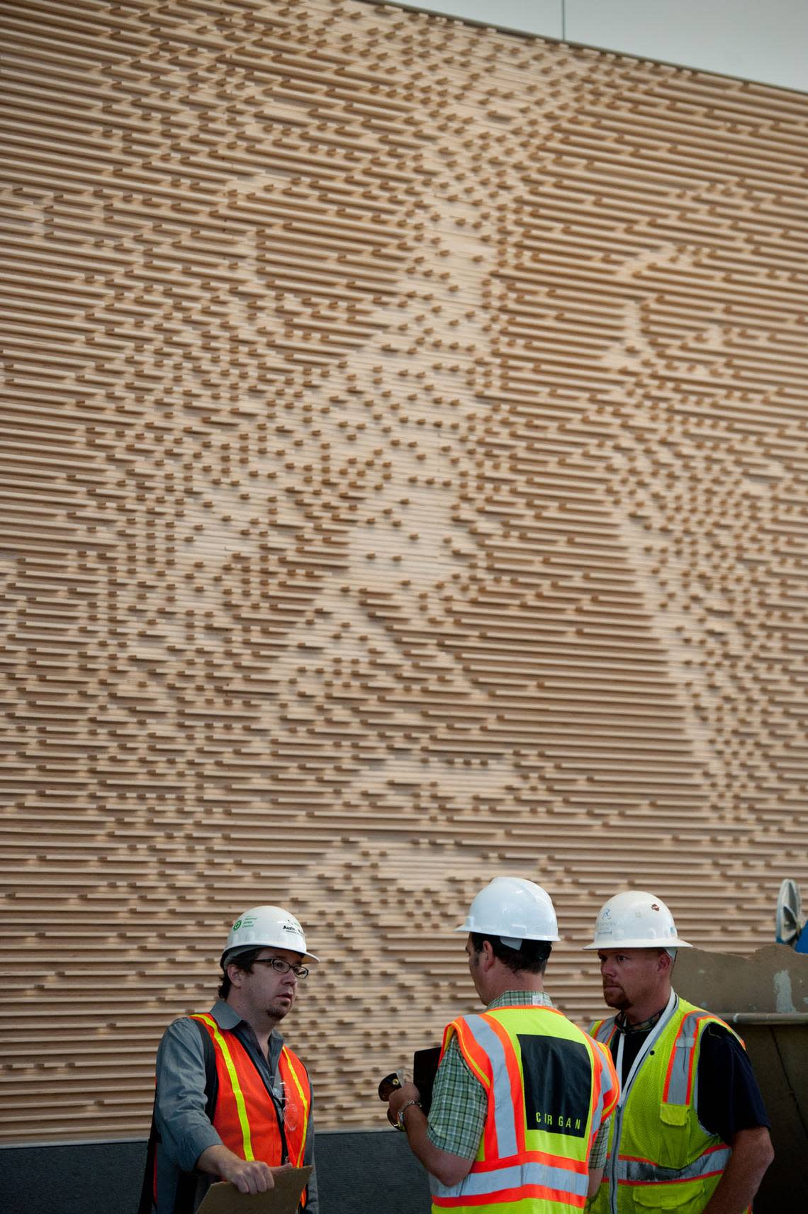 A portion of Christian Moeller’s “Baggage Handlers” hangs on the wall inside Terminal B at Sacramento International Airport in 2011. The artwork is made using layers of plywood. Moeller’s project manager, Rob Ley, left, discusses lighting with architect John Mares, center, and electrician Sean Stevens.