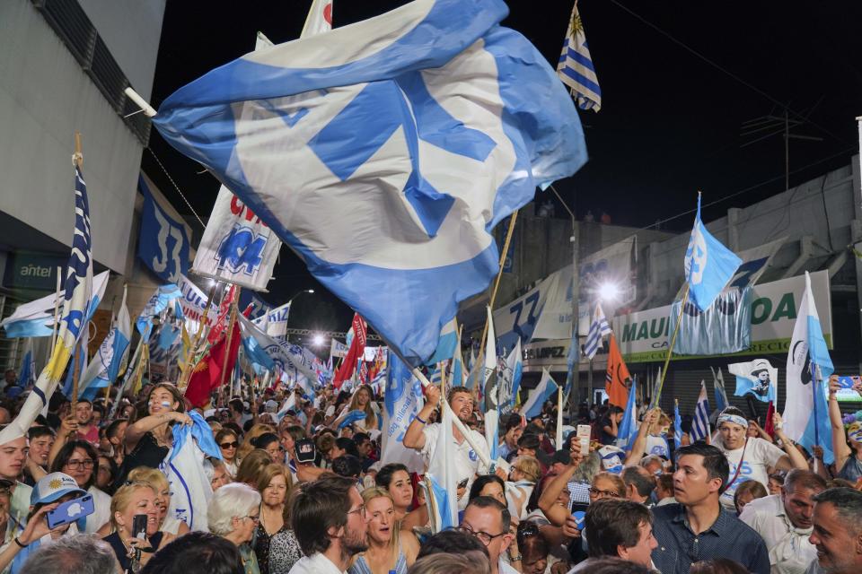 Supporters of Uruguay's presidential candidate for the National Party Luis Lacalle Pou cheer during his closing campaign rally in Las Piedras, Uruguay, Wednesday, Nov. 20, 2019. Uruguay will hold run-off presidential elections on Nov. 24 between presidencial candidate for the National Party, Luis Lacalle Pou and Daniel Martinez, of the ruling party Broad Front. (AP Photo/Matilde Campodonico)