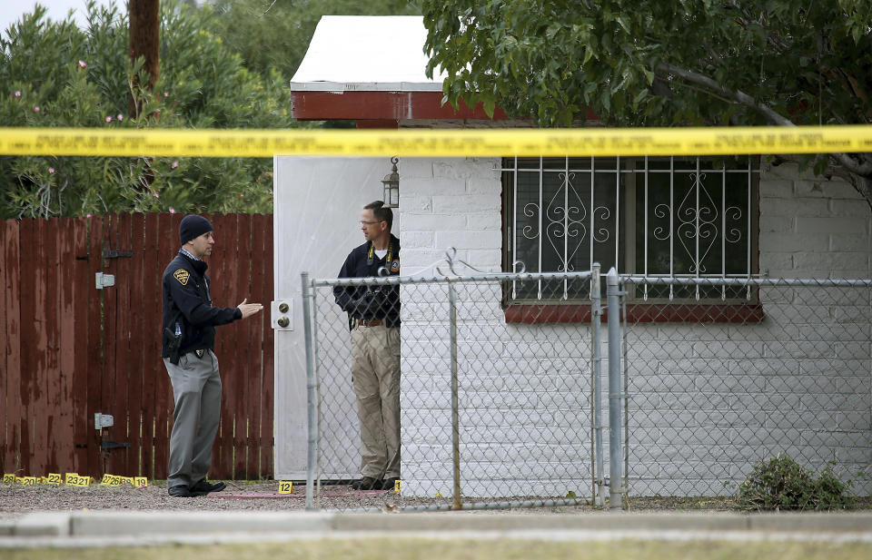 Law enforcement personnel continue their investigation at the scene following a shooting Friday, Nov. 30, 2018, in Tucson, Ariz. A deputy U.S. marshal serving a felony arrest warrant was shot and killed outside the Tucson house the night before. The suspect was arrested after an hour-long standoff at the home. (Ron Medvescek/Arizona Daily Star via AP)