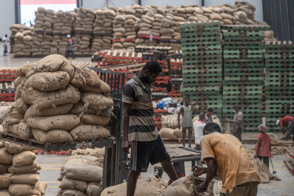 Workers unload sacks of cocoa beans from plantations at a cocoa processing plant in Abidjan, Ivory Coast.