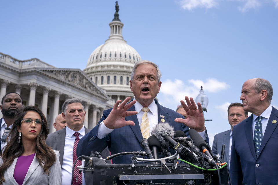 Representative Ralph Norman speaks at a podium outdoors surrounded by colleagues.