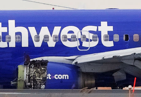 Emergency personnel monitor the damaged engine of Southwest Airlines Flight 1380, which diverted to the Philadelphia International Airport this morning after the airline crew reported damage to one of the aircraft's engines, on a runway in Philadelphia, Pennsylvania U.S. April 17, 2018. REUTERS/Mark Makela