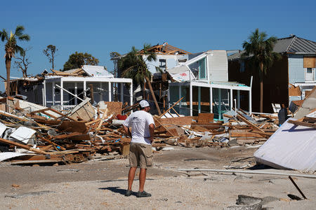 A man walks along a street following Hurricane Michael in Mexico Beach, Florida, U.S., October 12, 2018. REUTERS/Carlo Allegri