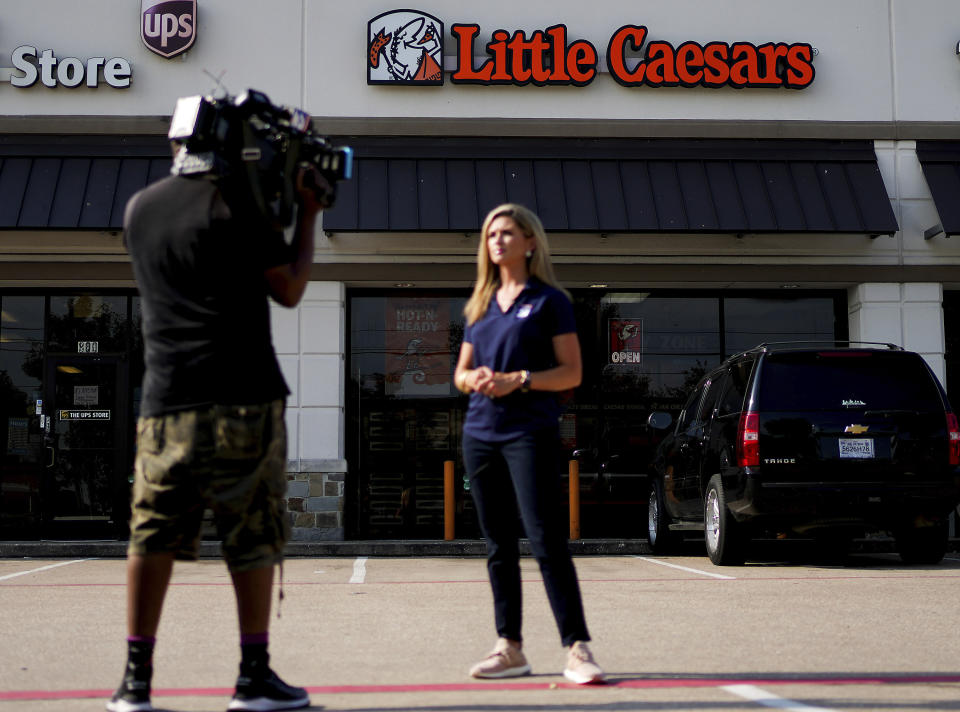 Local media gathers in front of a Little Caesars Pizza where an employee was pistol whipped over a wrong order, leading to a police search for the suspect, who is now accused of ambushing a Harris County Sheriff's Deputy Thursday, July 11, 2024, in Houston. (Elizabeth Conley/Houston Chronicle via AP)