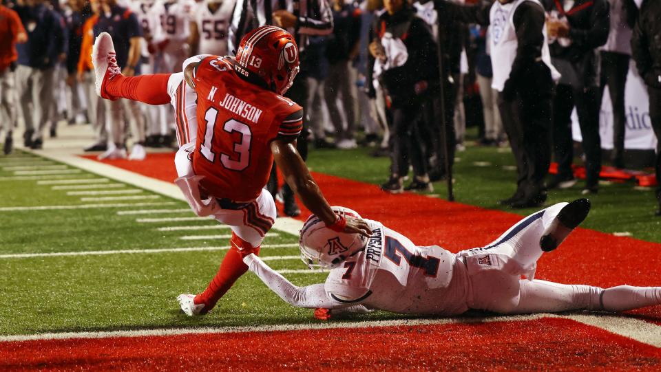 Utah Utes running back Nate Johnson spins into the end zone for a touchdown over Arizona Wildcats cornerback Ephesians Prysock.