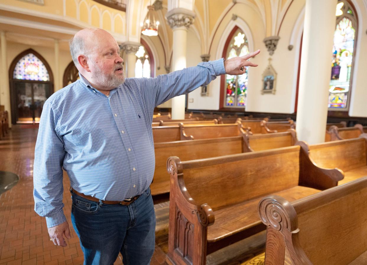 Robert Sullivan, organist and director of music/liturgy for the Basilica of Saint John the Baptist and Saint Peter Church in Canton, points out the stained-glass windows at Saint John.