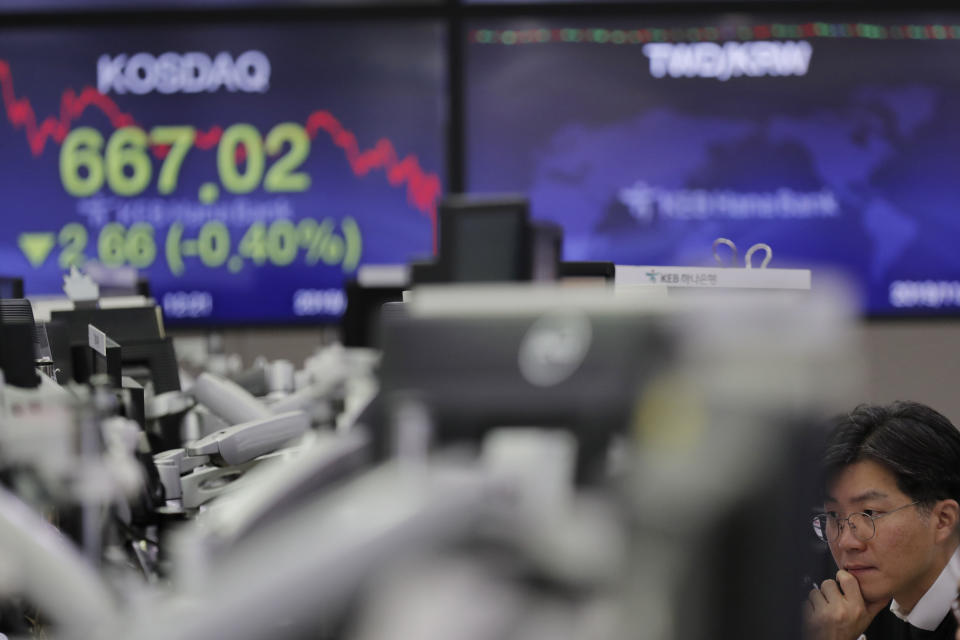 A currency trader watches computer monitors near the screen showing the Korean Securities Dealers Automated Quotations (KOSDAQ), left, at the foreign exchange dealing room in Seoul, South Korea, Thursday, Nov. 7, 2019. Asian stocks are mostly lower after a meandering day of trading left U.S. stock indexes close to their record highs. (AP Photo/Lee Jin-man)