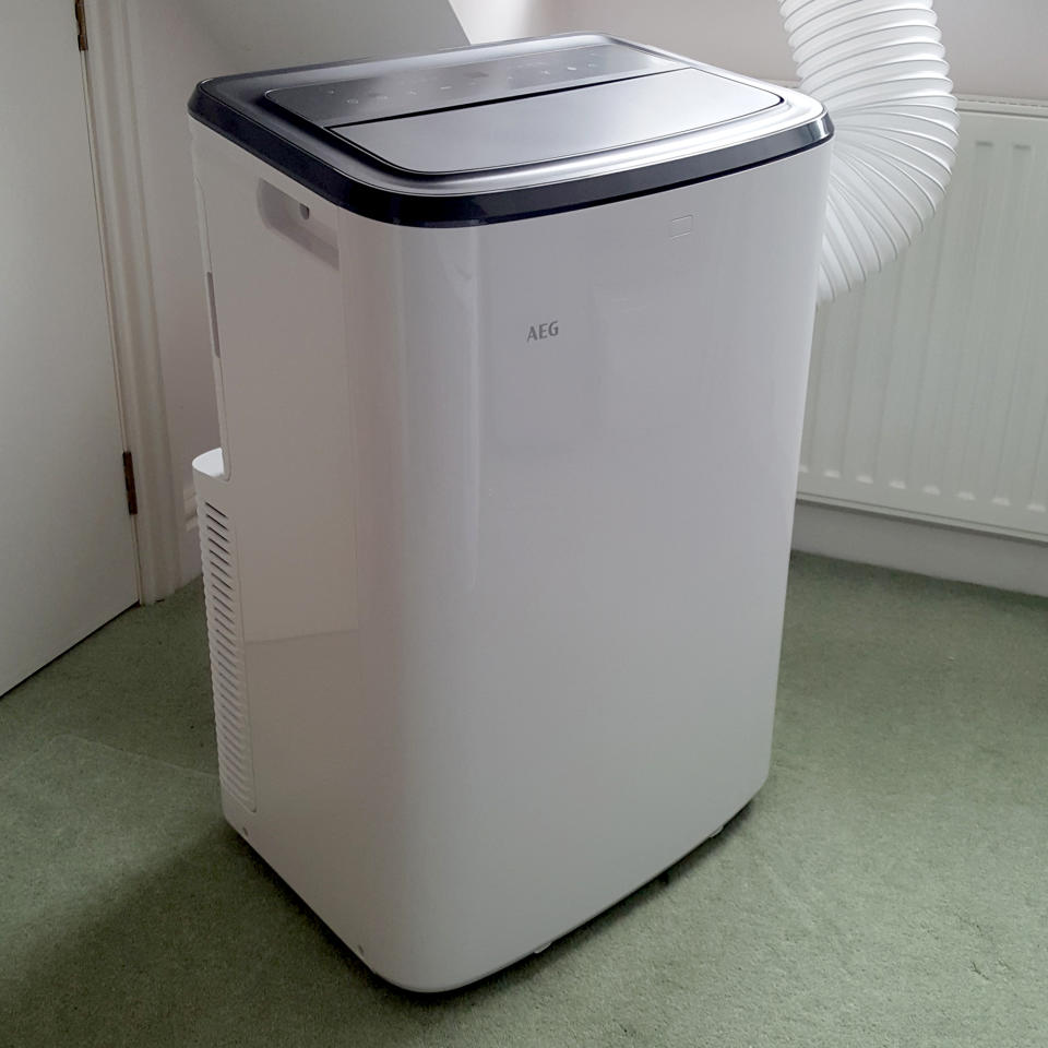 The AEG Comfort 6000 Portable Air Conditioner being tested in a room with green carpet