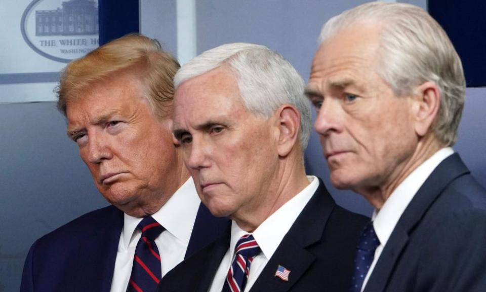 Donald Trump, Mike Pence and economic adviser Peter Navarro look on during a coronavirus briefing.