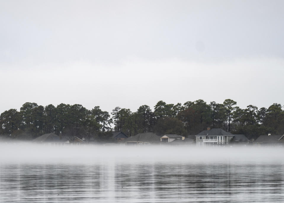 Fog is seen along homes on Lake Conroe, Wednesday, Jan. 24, 2024, in Conroe, Texas. The San Jacinto River Authority closed the lake to boating and other activities for safety reasons. (Jason Fochtman/Houston Chronicle via AP)