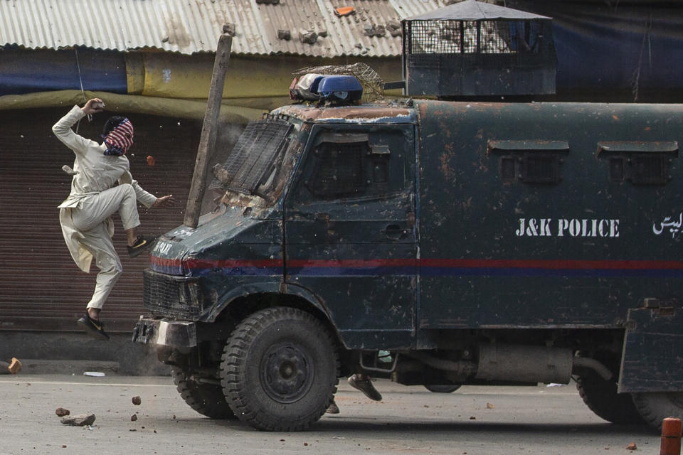 A masked Kashmiri protester jumps on the bonnet of an armored vehicle of Indian police as he throws stones at it during a protest in Srinagar, Indian controlled Kashmir, May 31, 2019. The image was part of a series of photographs by Associated Press photographers which won the 2020 Pulitzer Prize for Feature Photography. (AP Photo/Dar Yasin)