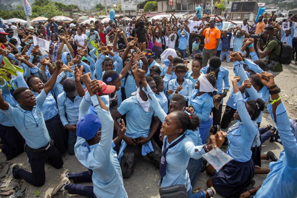 Students in their school uniform kneel chanting anti-government slogans during a protest march to demand answers after the kidnapping and murder of high school senior Evelyne Sincère, in Port-au-Prince, Haiti, Thursday, Nov. 5, 2020. The young woman was found in a trash heap Sunday after relatives said they were unable to pay the large ransom demanded by her captors. Human rights groups contend the incident highlights the nation’s worsening security crisis. (AP Photo/Dieu Nalio Chery)