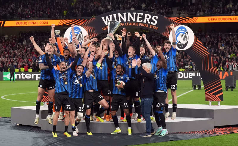 Atalanta players celebrate the title with the trophy after the UEFA Europa League final soccer match between Atalanta Bergamo and Bayer Leverkusen at the Aviva Stadium. Niall Carson/PA Wire/dpa