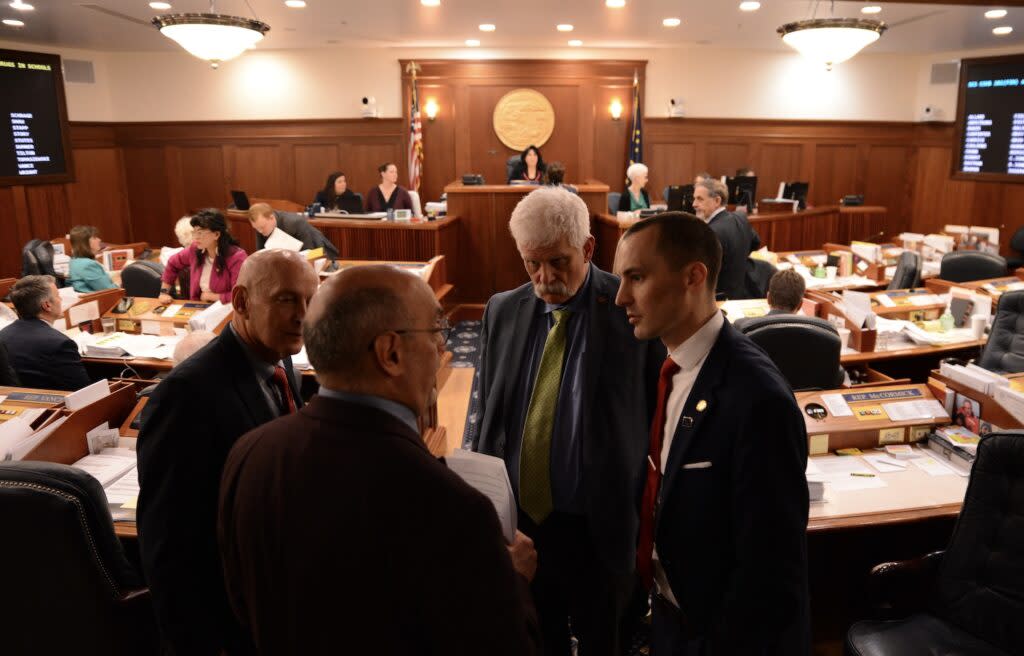 Members of the Alaska House's minority caucus huddle for a conversation on Wednesday, May 15, 2024, during a break in the House floor session. (Photo by James Brooks/Alaska Beacon)
