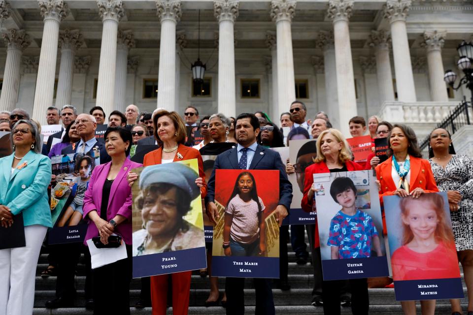 House SpeakerNancy Pelosi, D-Calif., stands with fellow Democrats holding photographs of the victims of the mass shootings in Buffalo, New York and Uvalde, Texas, before passing the Bipartisan Safer Communities Act in front of the House of Representatives on June 24, 2022, in Washington, D.C.