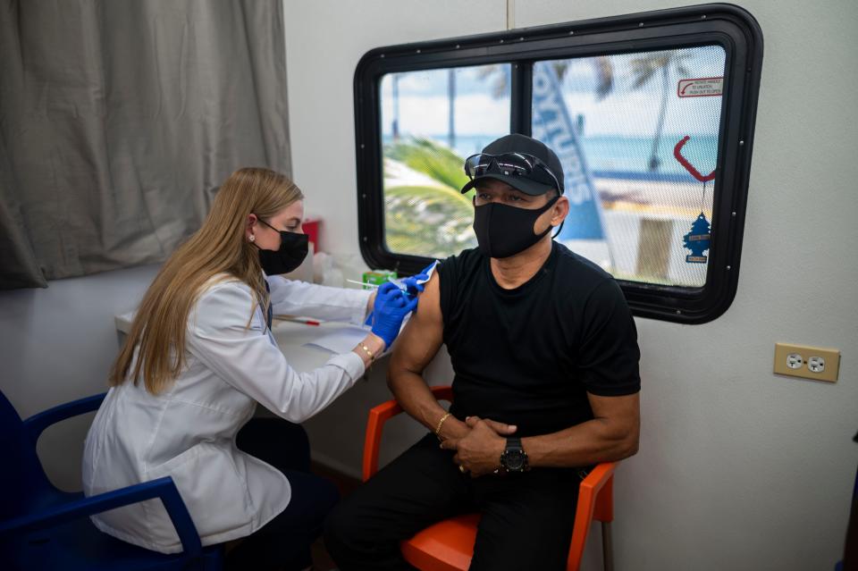 A health care worker inoculates Raymon Diaz, 59, with a dose of the Johnson & Johnson COVID-19 vaccine during a vaccination campaign in San Juan, Puerto Rico.