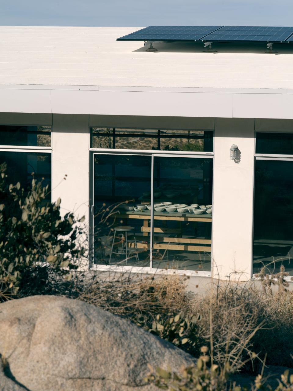 The studio building, with greenware A-Z Containers drying in the window. Since the 1990s Zittel has used bowls for all eating and drinking. Her studio sells weavings and the containers through A-Z West Works.