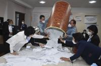 Members of an election commission pulls ballots out of a box preparing to count them at a polling station after the presidential election in Tashkent, Uzbekistan, Sunday, Oct. 24, 2021. Uzbekistan's President, Shavkat Mirziyoyev, who has relaxed many of the policies of his dictatorial predecessor but has made little effort at political reform, is expected to win a new term by a landslide against weak competition in an election Sunday. (AP Photo)