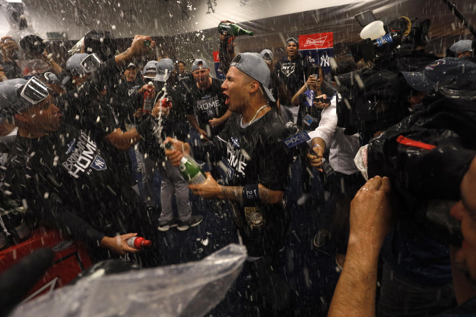 New York Yankees players celebrate in the locker room after their 5-1 victory over the Minnesota Twins in Game 3 of a baseball American League Division Series, late Monday, Oct. 7, 2019, in Minneapolis. (AP Photo/Bruce Kluckhohn)