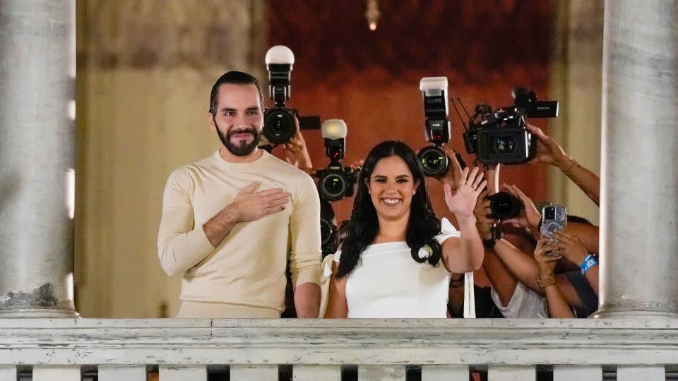 El Salvador President Nayib Bukele, left, accompanied by his wife Gabriela Rodriguez, waves to supporters from the balcony of the presidential palace in San Salvador, El Salvador, after polls closed on Sunday. - Moises Castillo/AP