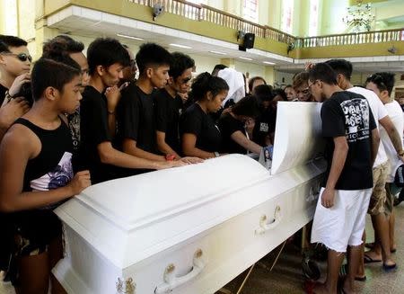 Relatives and friends look at the coffin of Eric Quintinita Sison during burial rites in Pasay city, metro Manila, Philippines August 31, 2016. Picture taken August 31, 2016. REUTERS/Czar Dancel