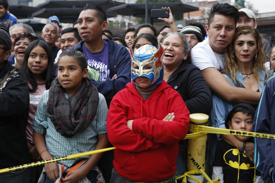 A crowd watches a "lucha libre" fight in Mexico City, Saturday, Dec. 21, 2019. Mexican wrestling, otherwise known as the “lucha libre,” is a highly traditional form of light entertainment. (AP Photo/Ginnette Riquelme)