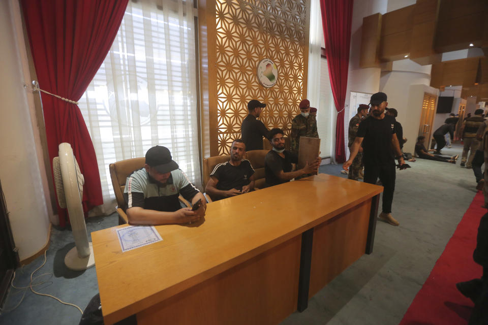 Iraqi protesters rest in the Parliament building in Baghdad, Iraq, Saturday, July 30, 2022 as thousands of followers of an influential Shiite cleric breached the building for the second time in a week to protest the government formation efforts lead by Iran-backed groups.(AP Photo/Anmar Khalil)