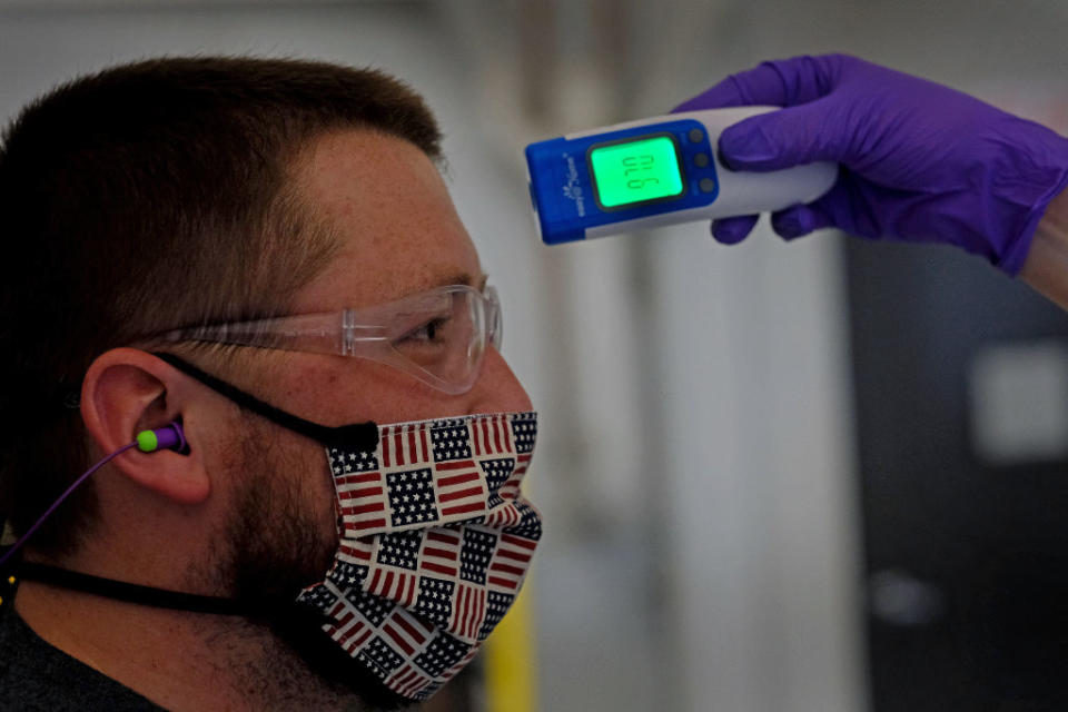 Kyle Pearson has his temperature checked at the start of his shift at Vibram Corporation in North Brookfield, MA.  